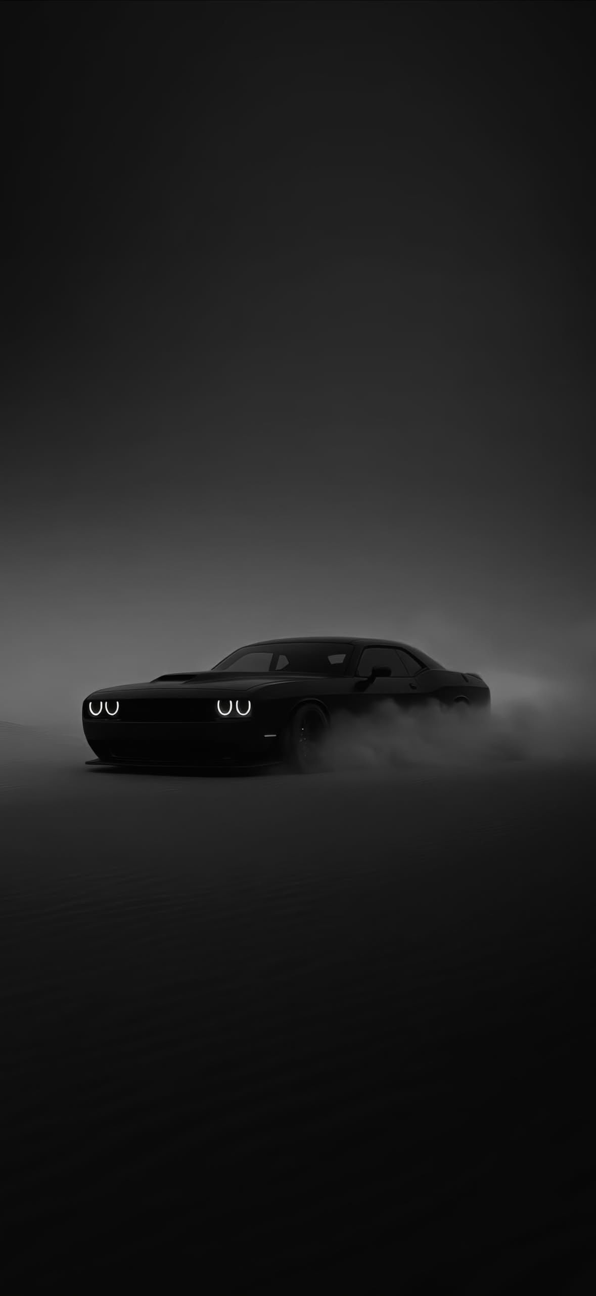 a black car in the dark with fog coming out of it's hoods
