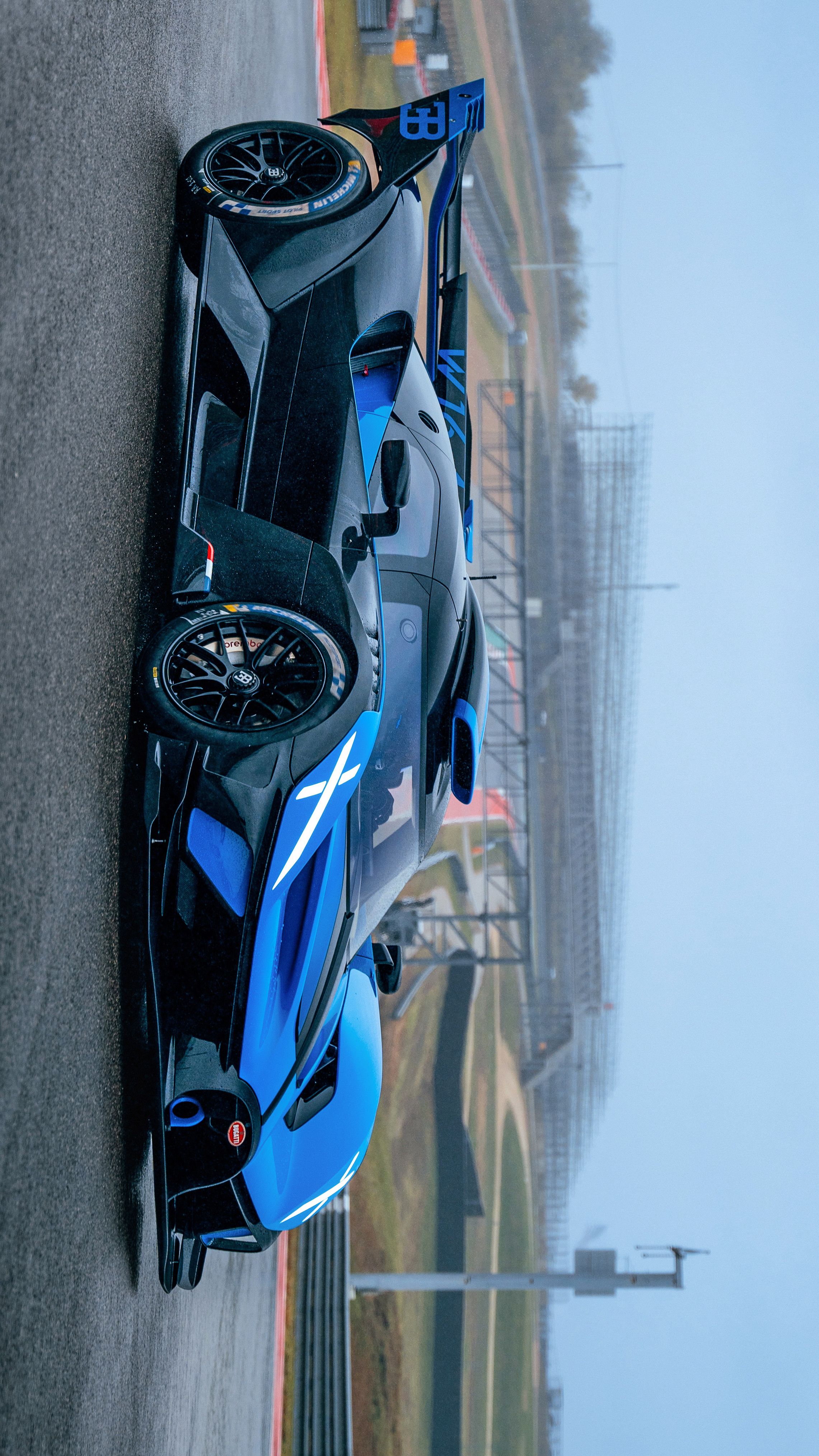 a blue race car driving down the road