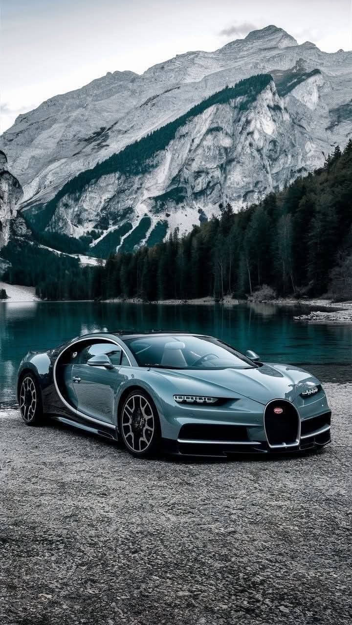 a bugatti car parked in front of a mountain lake