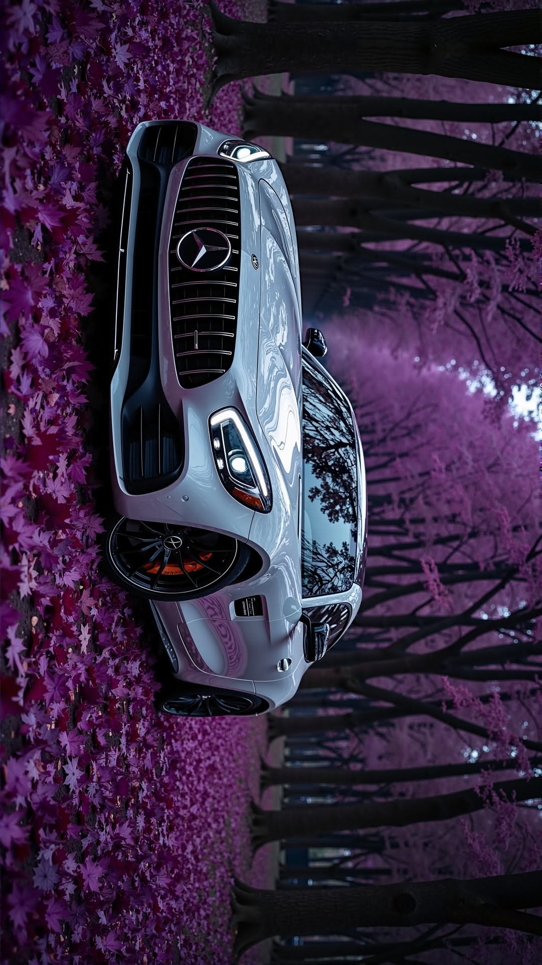 a car parked on the side of a road with trees in the background and purple flowers all around