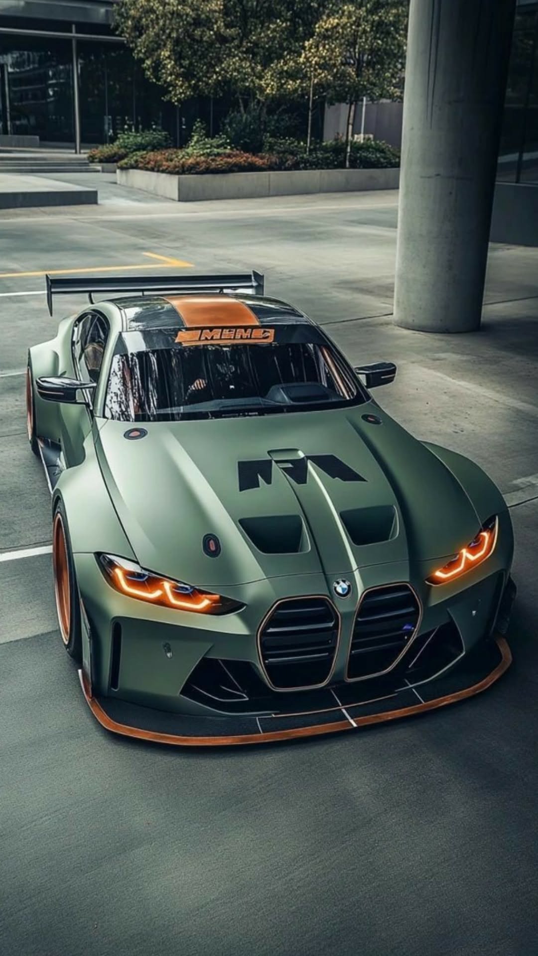 a green sports car driving down a street next to a parking lot with trees in the background