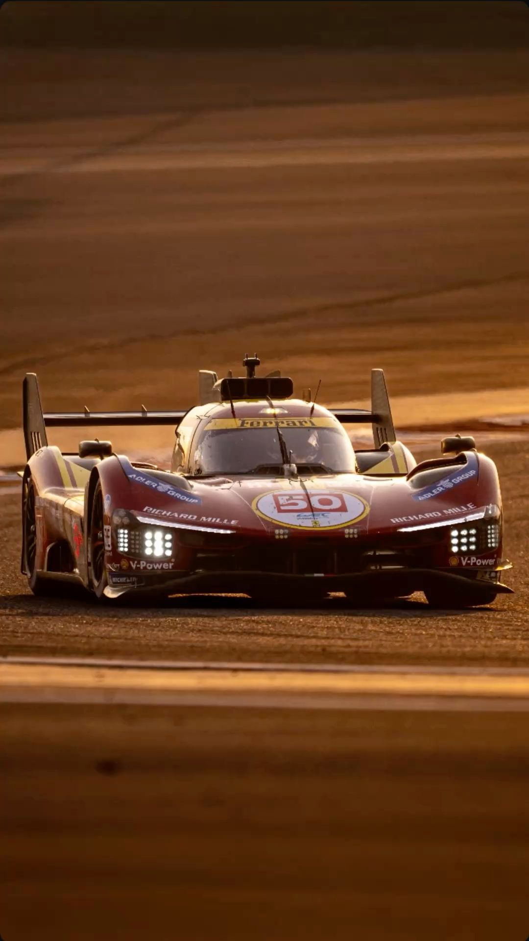 a race car driving on a track in the sun