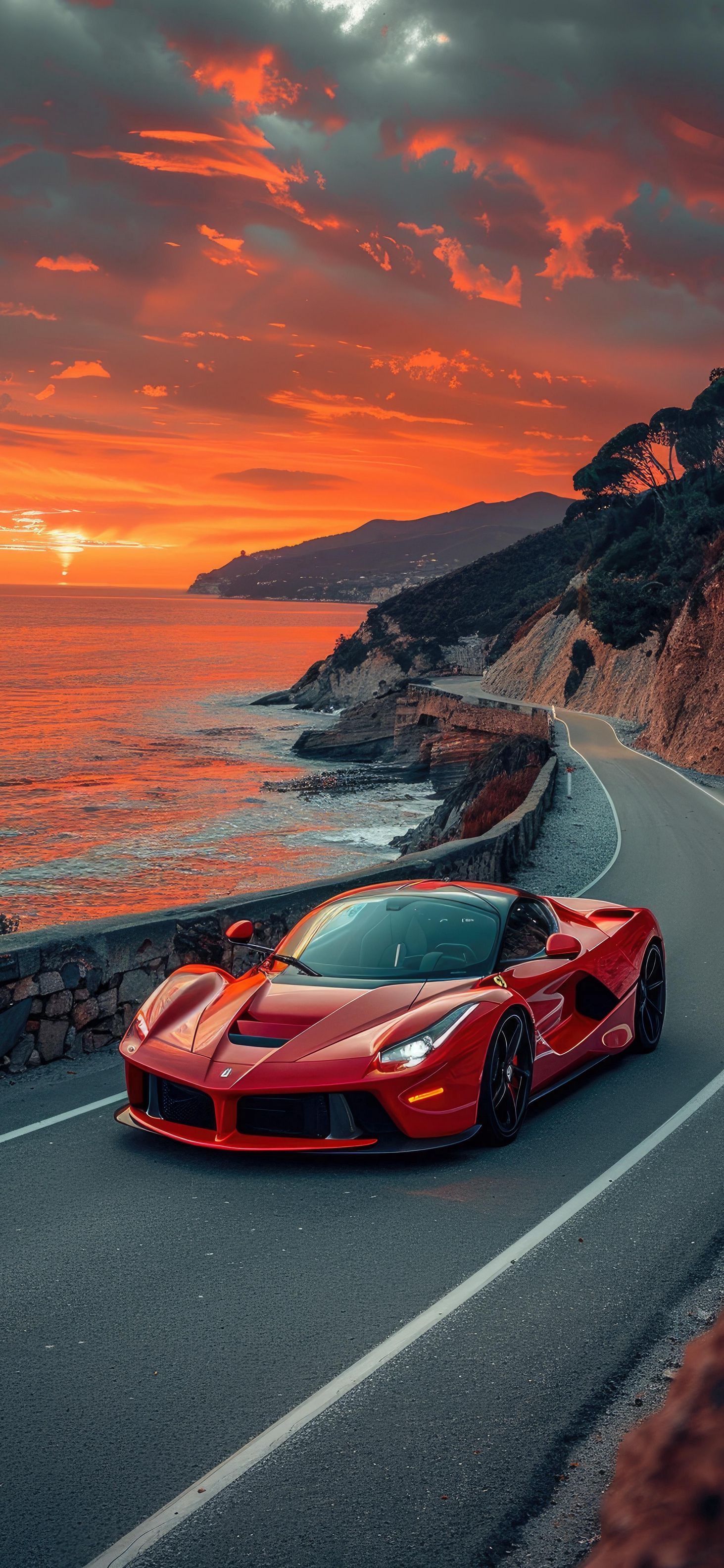 a red sports car driving down the road next to the ocean at sunset or sunrise