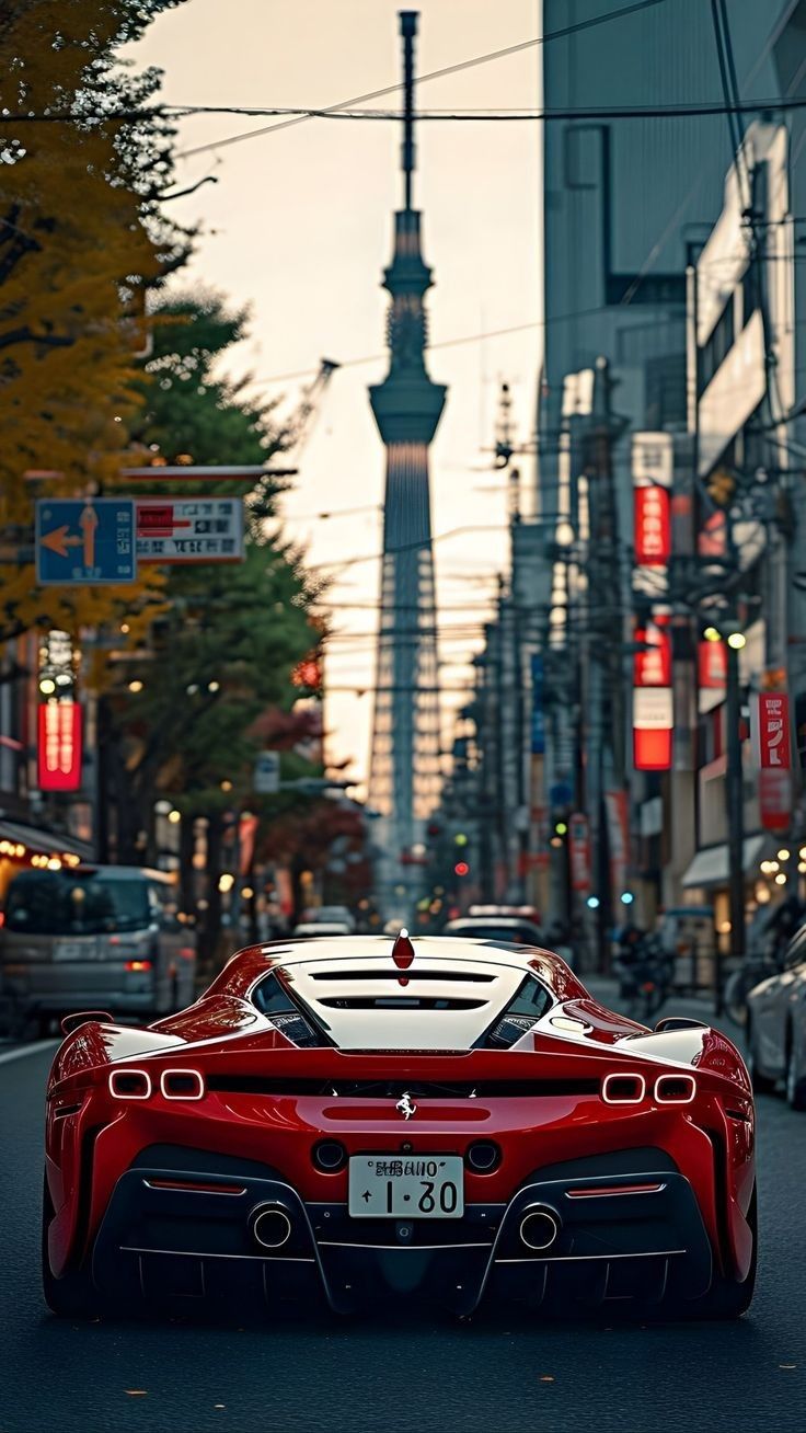 a red sports car is driving down the street in front of tall buildings and traffic lights
