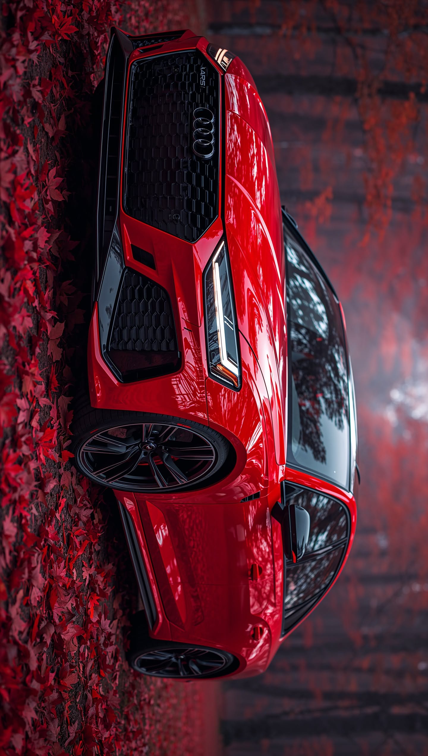 a red sports car parked on the side of a wall with leaves all over it