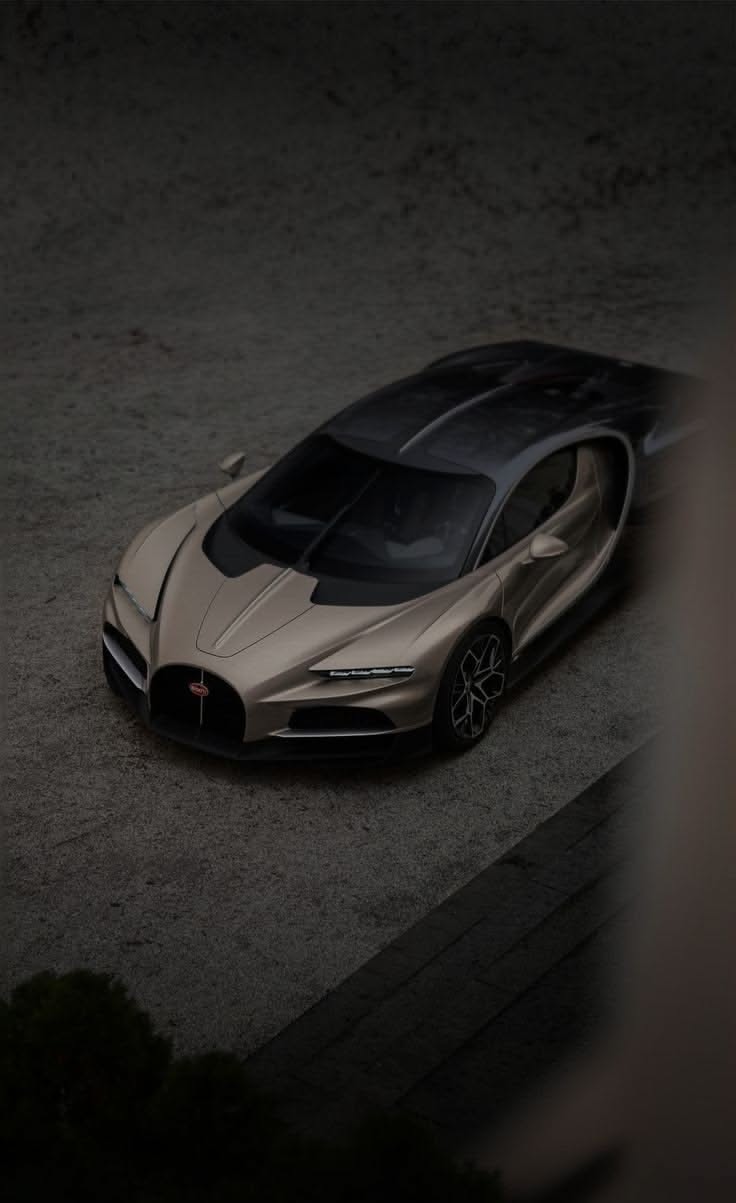 a silver bugatti is parked in the dark