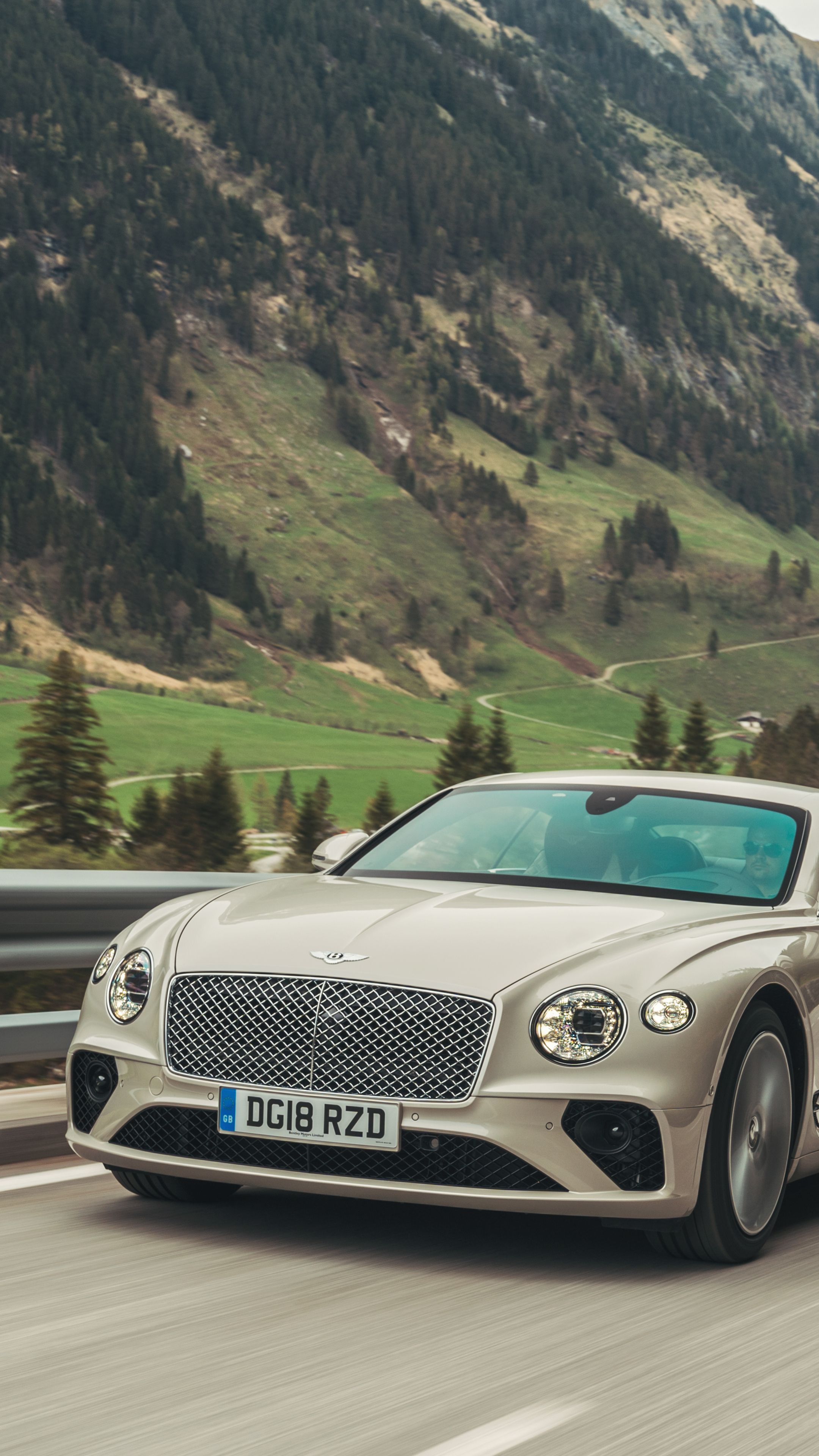 a silver car is driving down the road