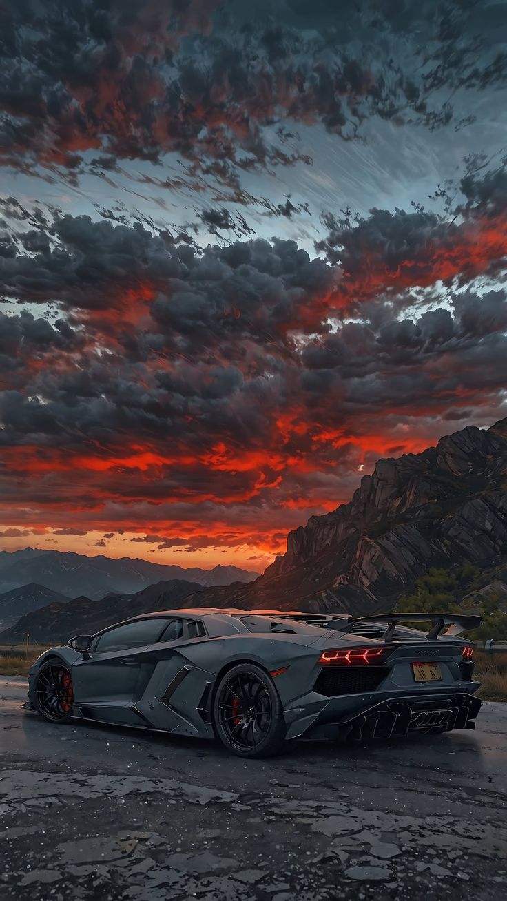 a sports car parked in front of a mountain at sunset