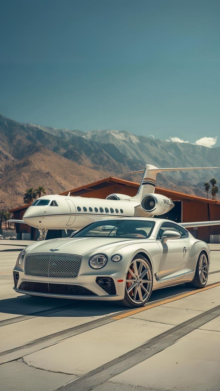 a white car parked in front of an airplane