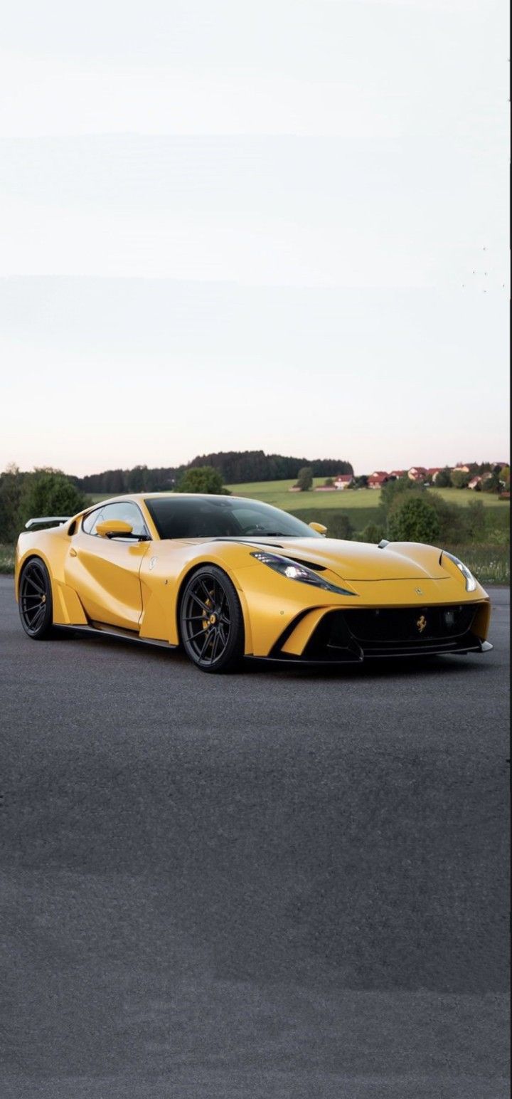 a yellow sports car is parked on the street