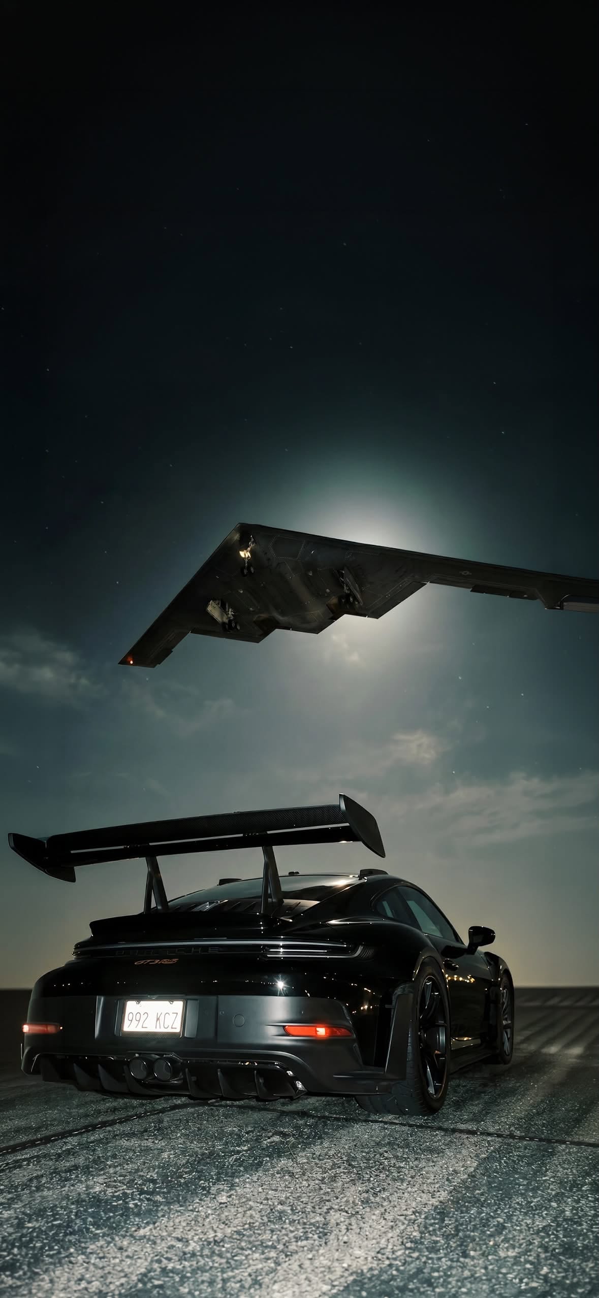 an airplane flying over a black sports car in the night sky with it's wing extended