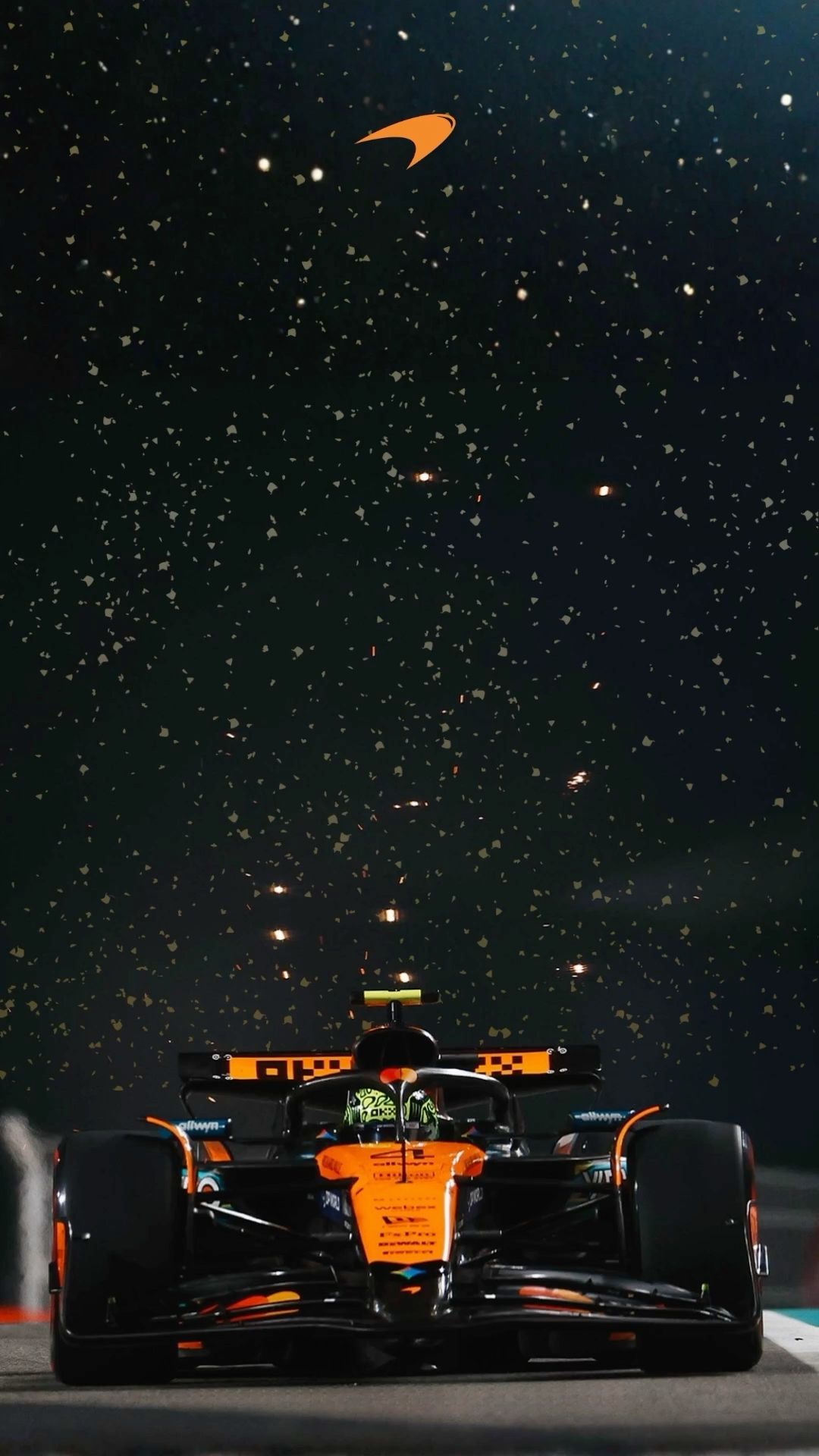 an orange race car driving on a track with stars in the night sky behind it
