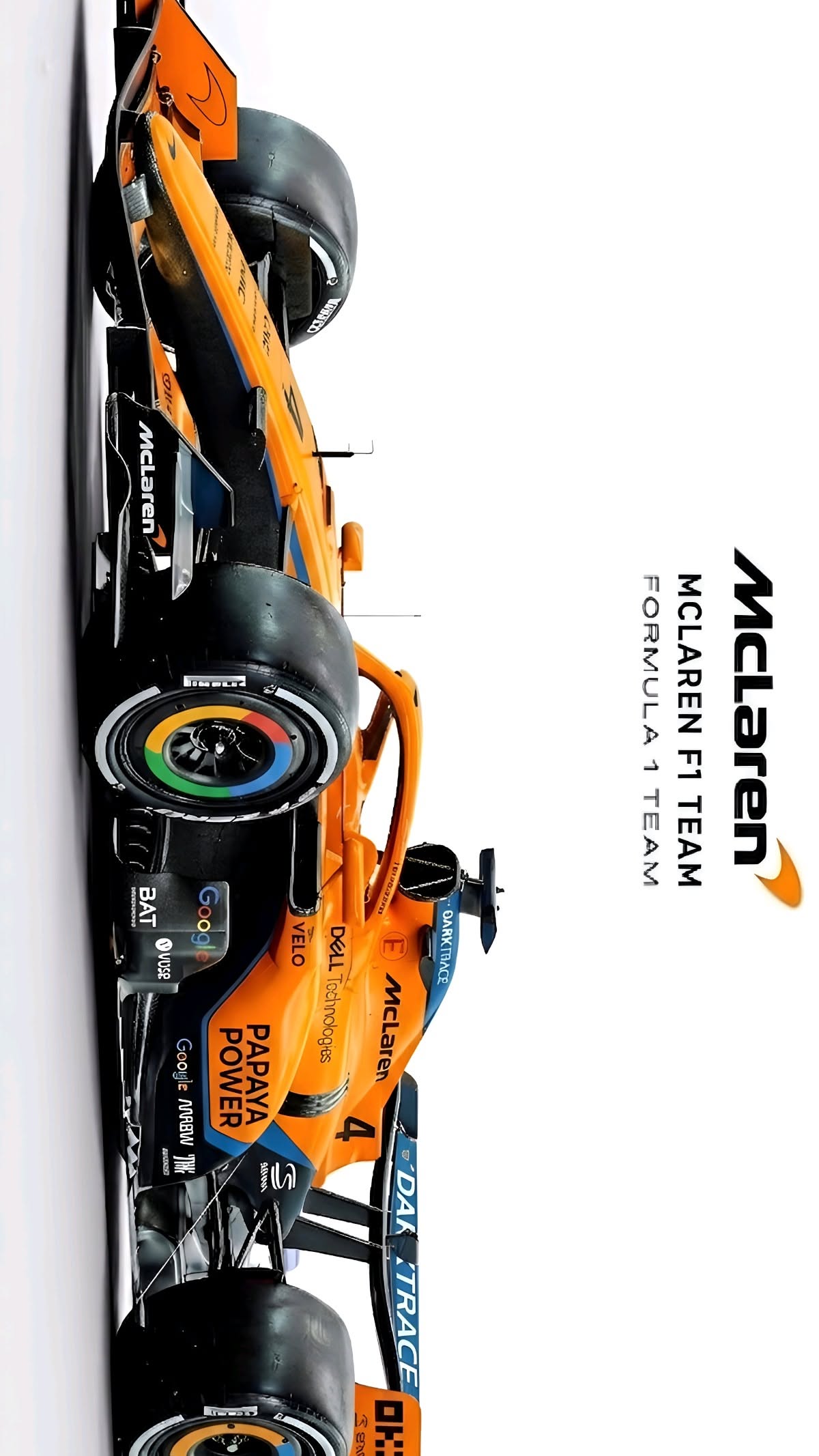 an orange race car is parked in front of a white wall