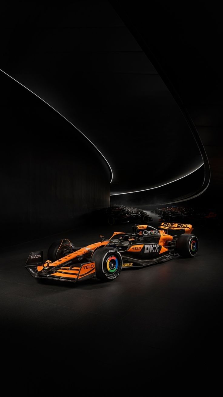 an orange race car is shown in the dark