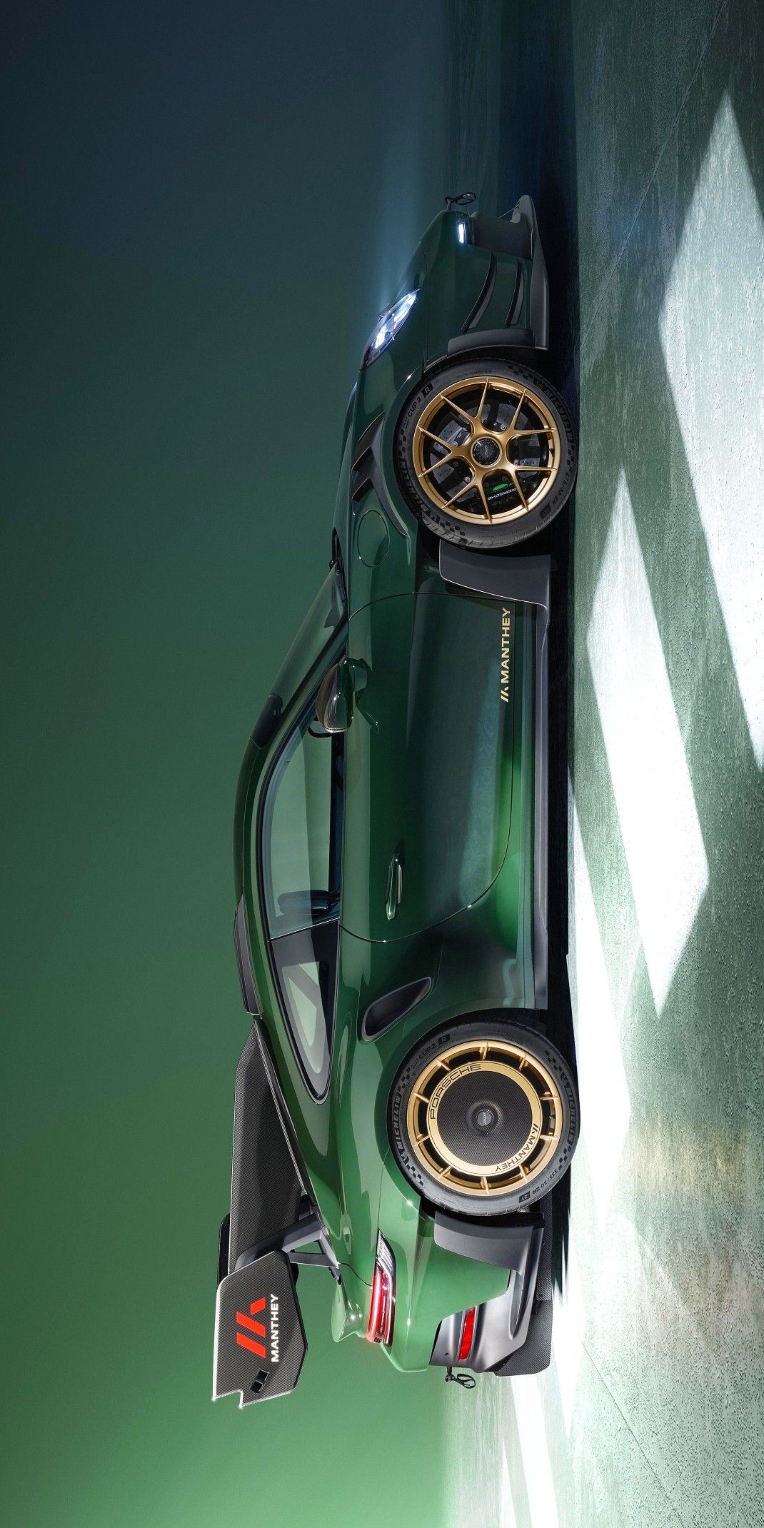 an overhead view of a green sports car with gold rims on it's wheels