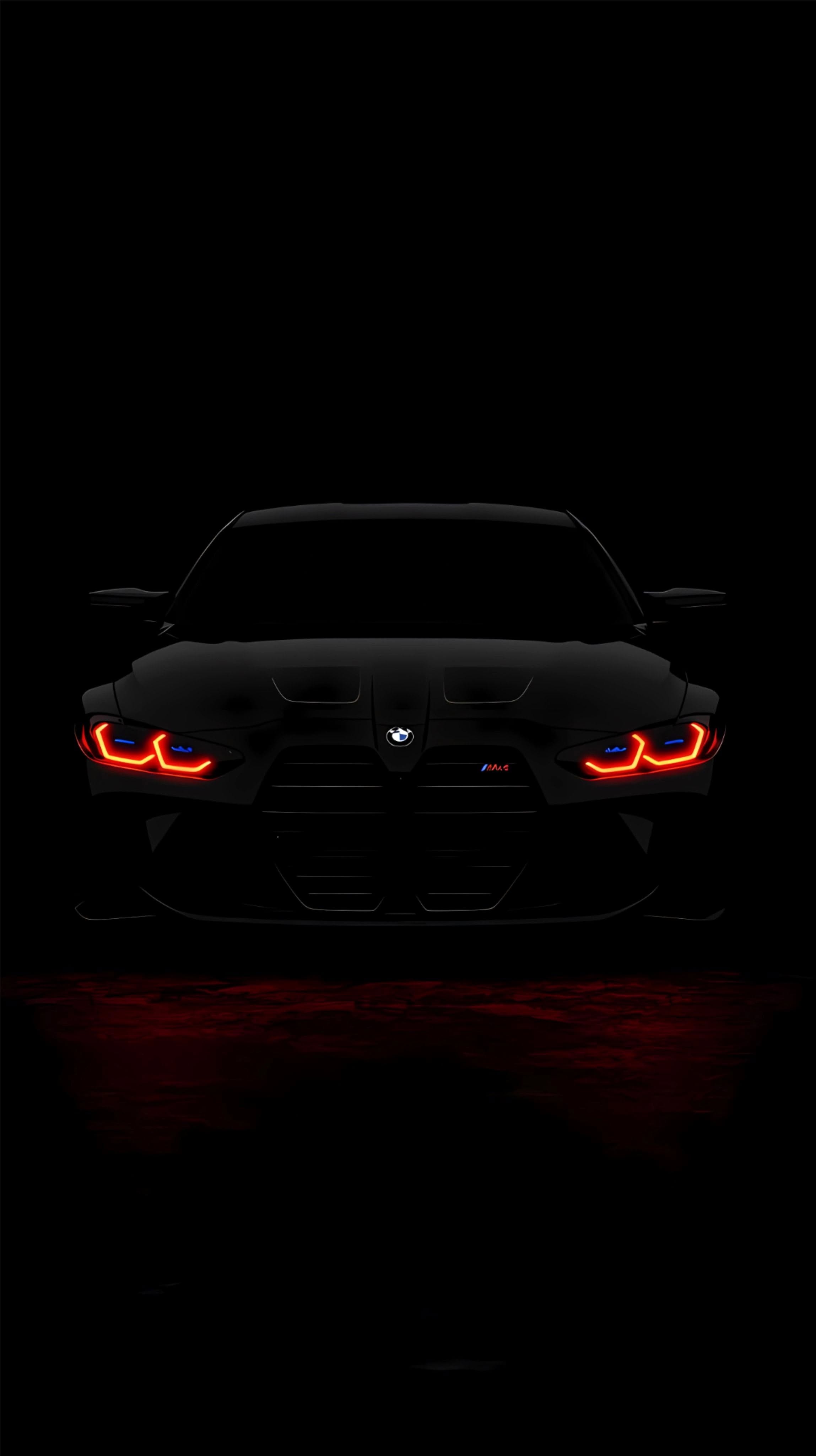 the front end of a black sports car with red lights on it's headlights