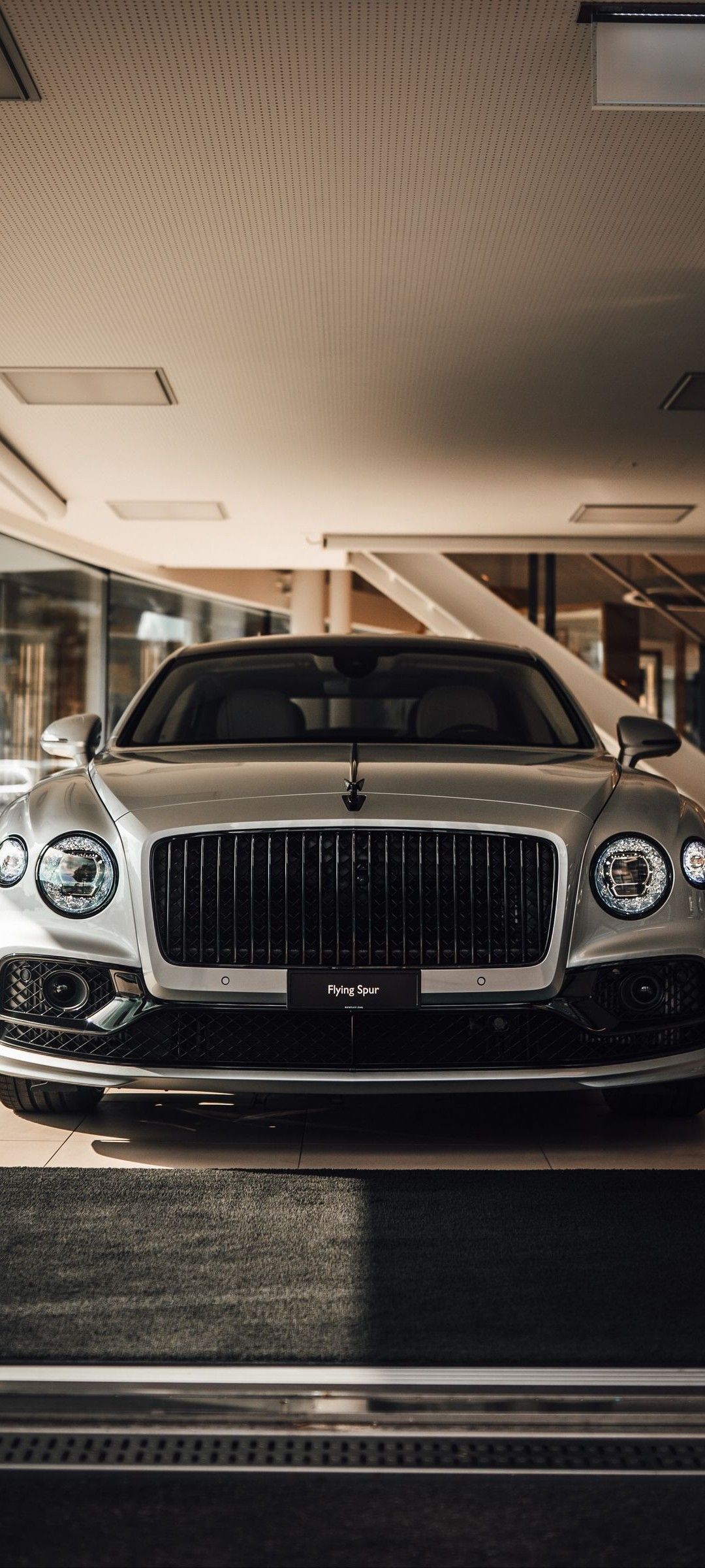 the front end of a silver car parked in a garage