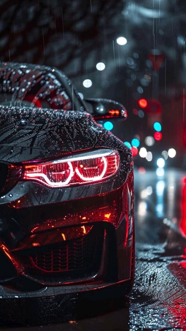 two cars parked in the rain at night